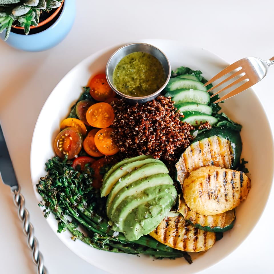 A colorful Banyan Kitchen cafe bowl with quinoa, grilled vegetables, avocado, and cherry tomatoes.